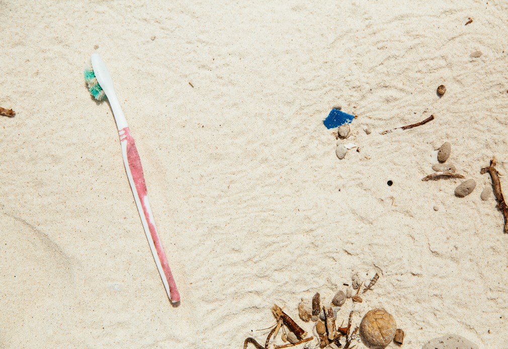 Oude tandenborstel op strand
