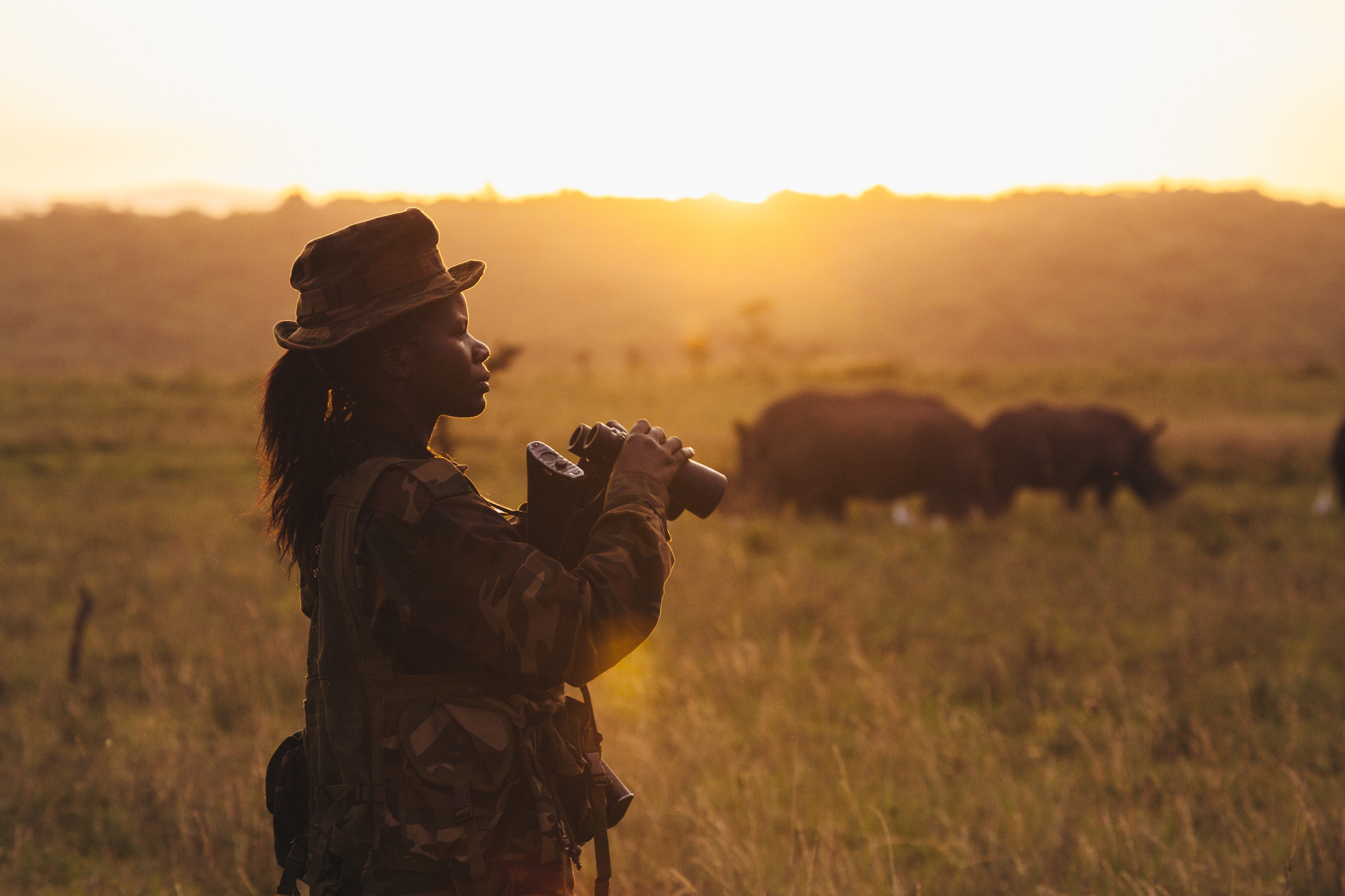 Ranger Doreen Adongo monitort neushoorns met verrekijker in Nairobi NP, Kenia