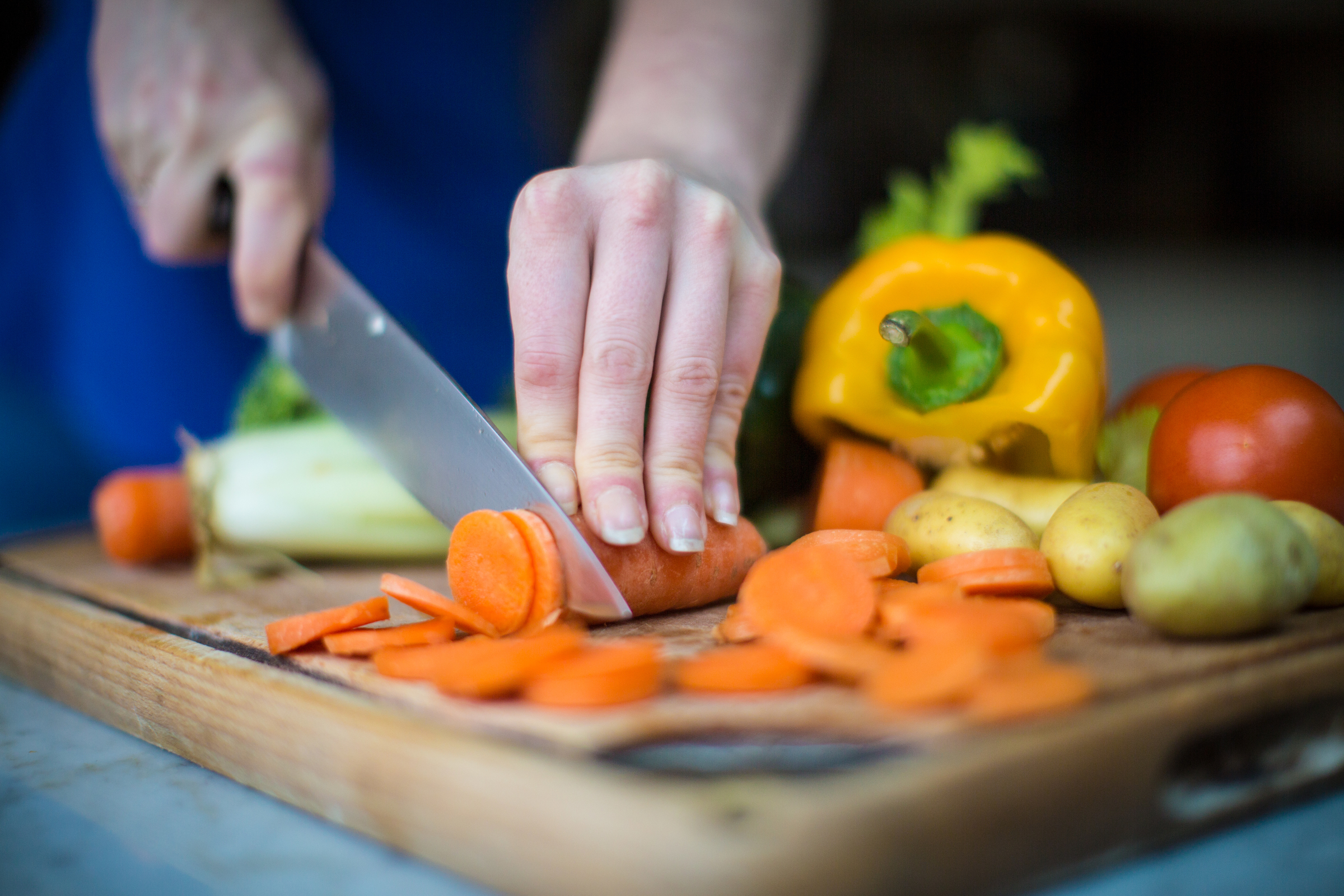 vrouw snijd met mes groenten